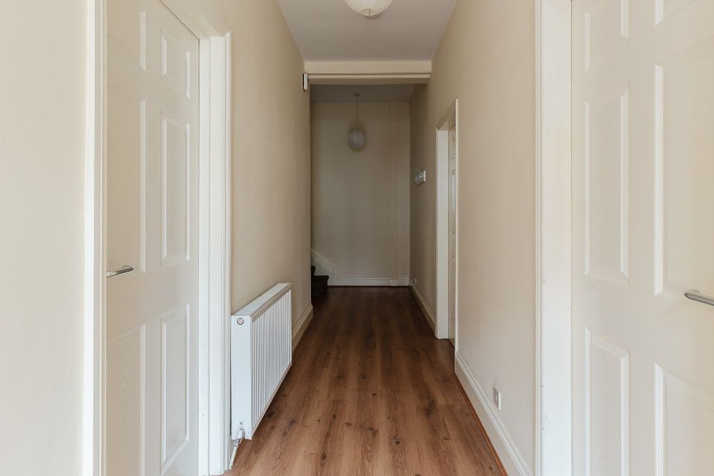 Property photo 2 of 7 A Well-Maintained Hallway Featuring Clean Wooden F...