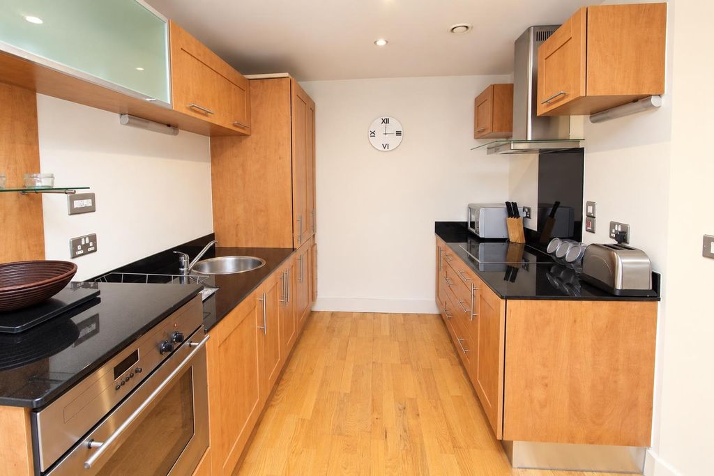 Property photo 2 of 8 Sleek Galley Kitchen With Ample Counter Space...