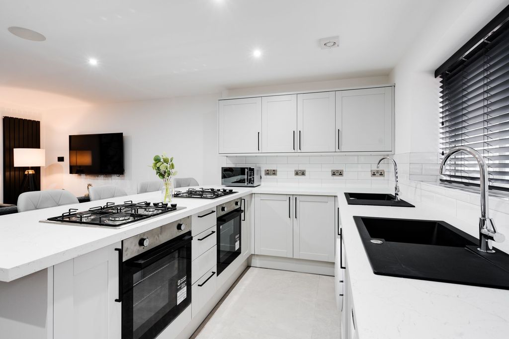 Property photo 3 of 8 Modern And Stylish Kitchen Featuring Sleek White c...