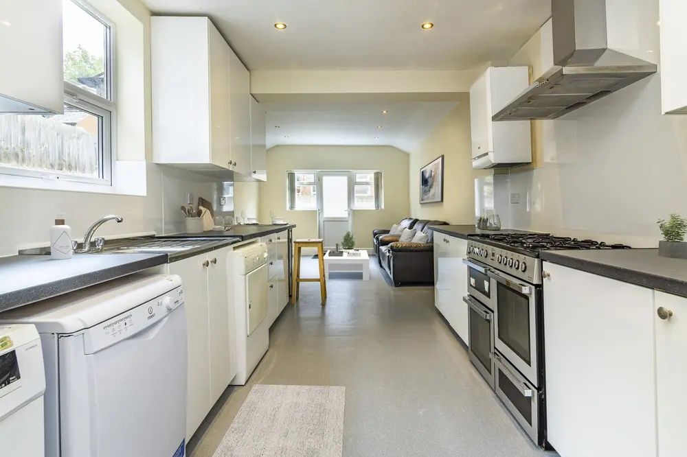 Property photo 3 of 8 Bright And Modern Kitchen Featuring Sleek White Ca...