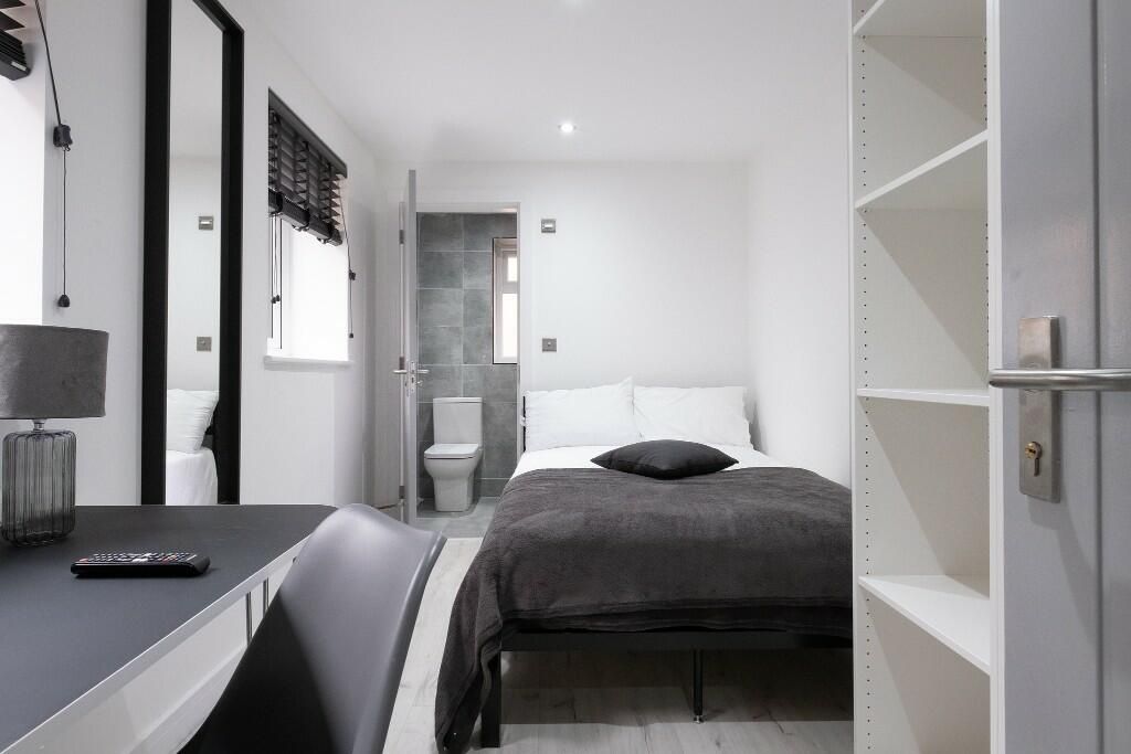 Property photo 1 of 15 A Modern, Well-Lit Bedroom Featuring A Comfortable...