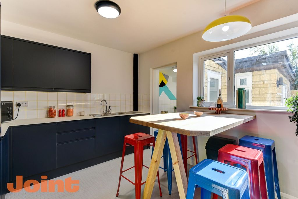 Property photo 3 of 6 A Modern Kitchen Featuring Sleek Dark Cabinetry An...