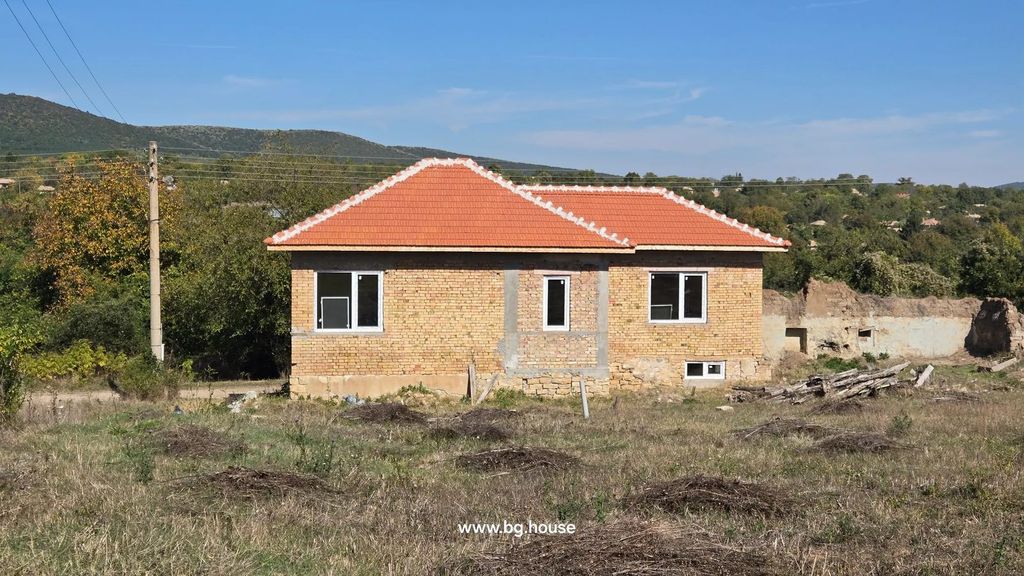 Property photo 2 of 28 Brick House With Red Tiled Roof And Three White-Framed Windows, With Hills And Trees In The Background.
