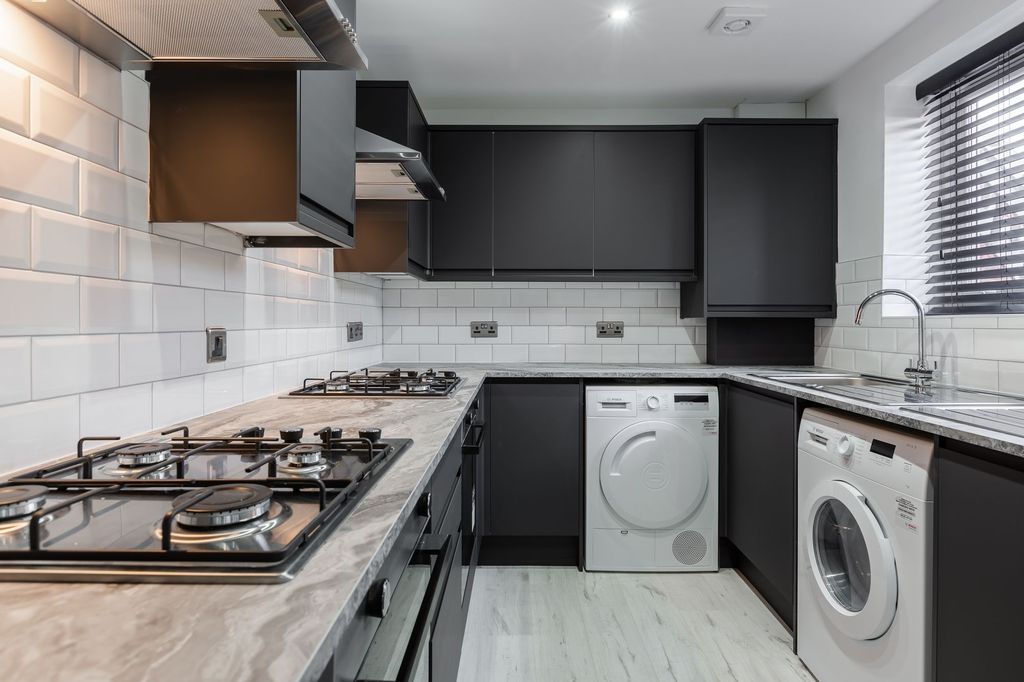 Property photo 2 of 7 Modern Kitchen Featuring Sleek Black Cabinetry, Wh...