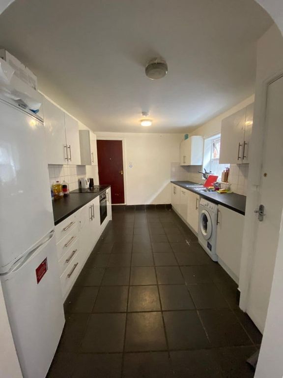 Property photo 2 of 7 A Spacious Kitchen With White Cabinetry And Black ...
