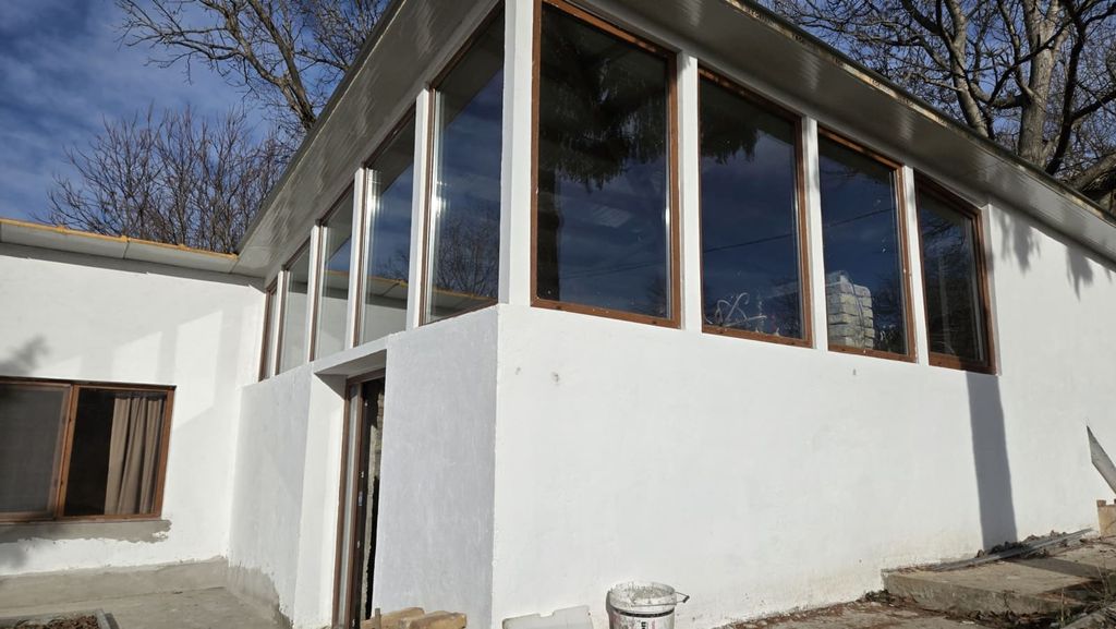 Property photo 3 of 50 Corner Of The House Showing Large Glass Windows And White Painted Walls
