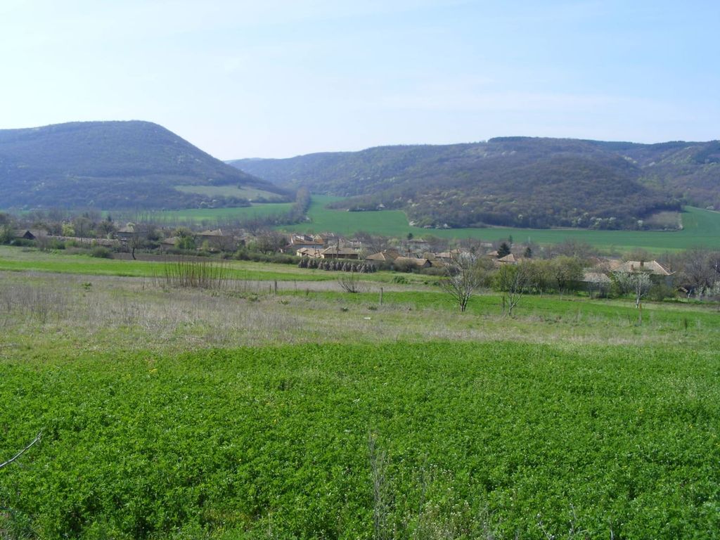 Property photo 1 of 39 View Of Green Fields And A Village With Forested Hills In The Distance Under A Clear Sky