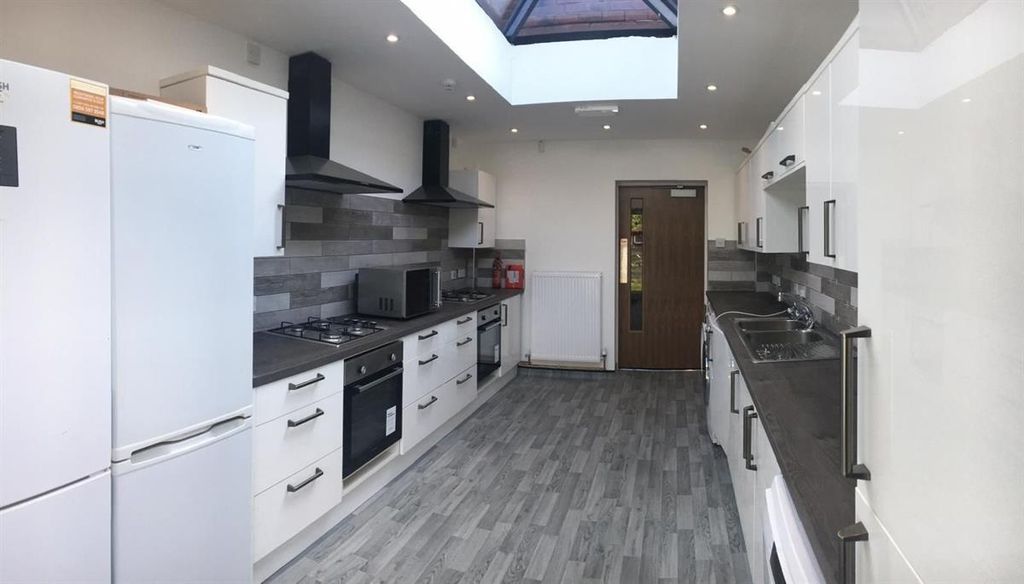 Property photo 3 of 15 Bright, Modern Galley Kitchen With Sleek White Cab...