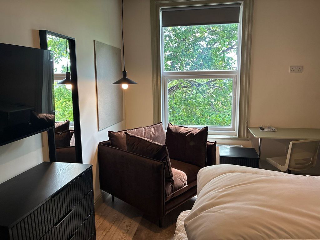 Property photo 3 of 4 Bright Bedroom With Cozy Chair And Desk Area...