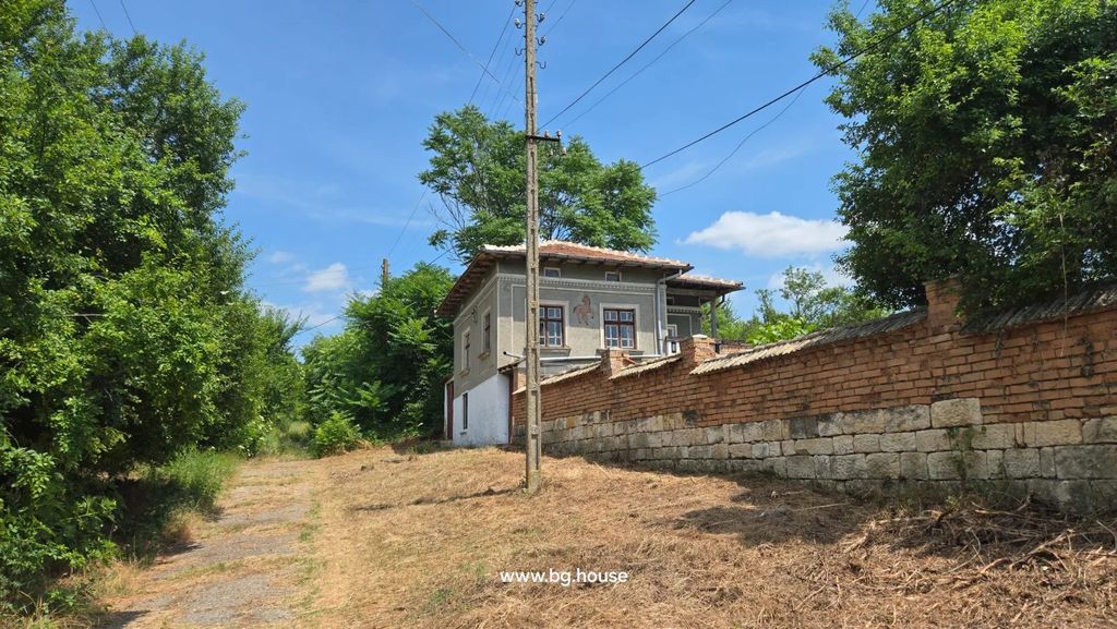 Property photo 1 of 72 Two-Storey House With Decorative Walls, Tiled Roof, Brick And Stone Fence, Dirt Path, And Greenery.