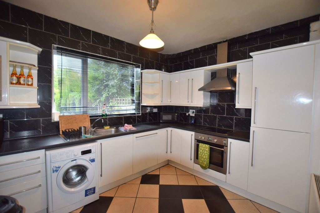 Property photo 3 of 7 Bright And Modern Kitchen Featuring Sleek White Ca...