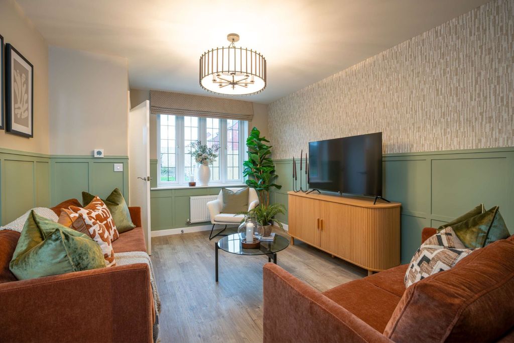 Property photo 3 of 8 Two Orange Sofas With Green And Patterned Pillows Face A Coffee Table And A TV On A Wooden Cabinet