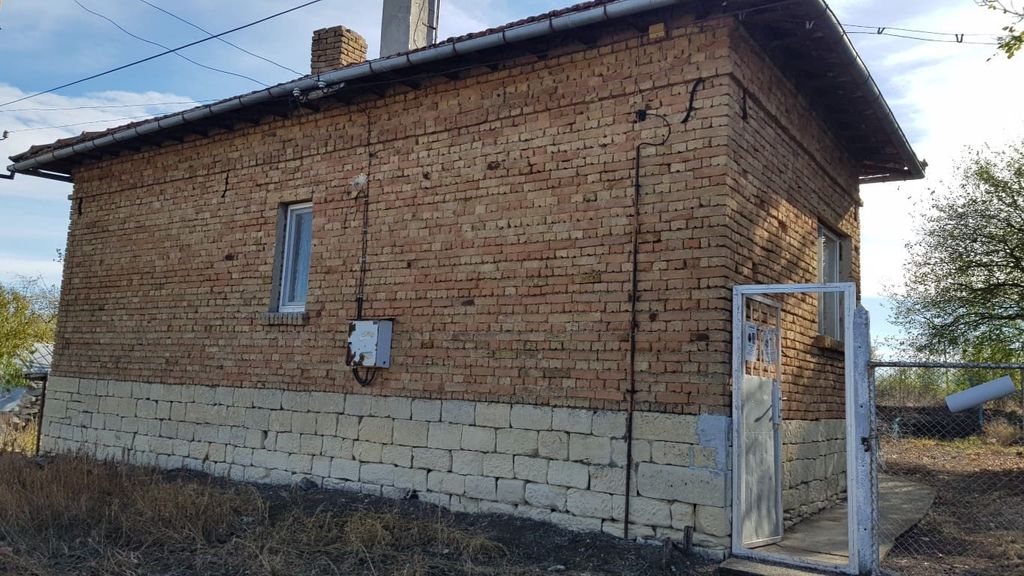 Property photo 3 of 36 Side Perspective Of A Small Brick House Showing Stone Foundation And Metal Gate Entrance