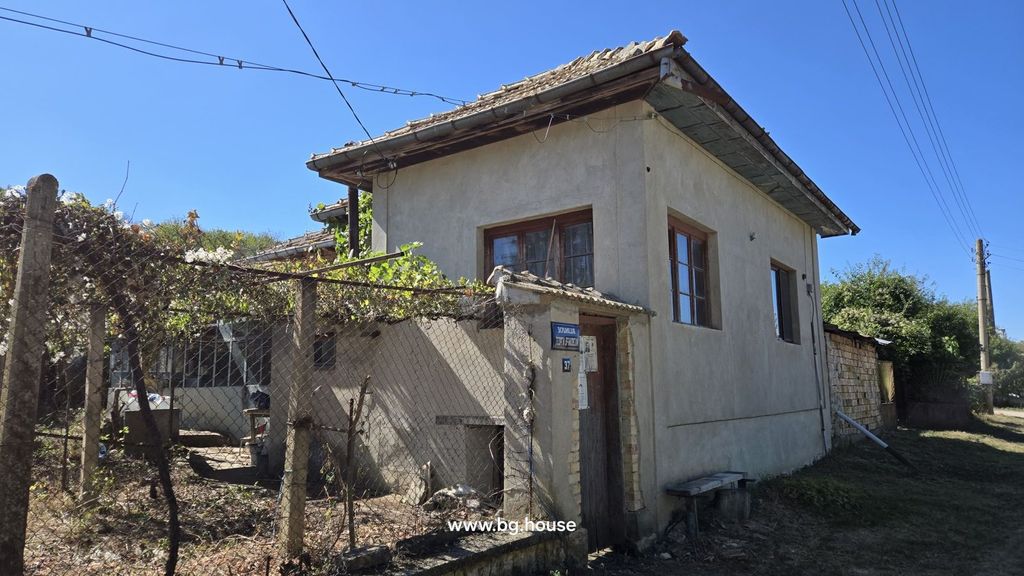 Property photo 2 of 100 Exterior Of A Two-Storey Village House With Plastered Walls And Wooden Windows, Featuring A Fenced Yard Covered With Grapevines