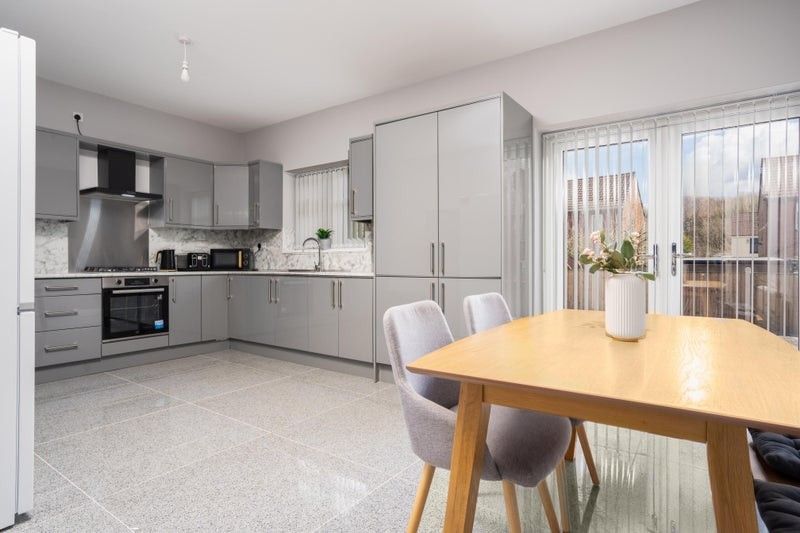 Property photo 3 of 9 A Modern Kitchen Featuring Sleek Grey Cabinetry, A...