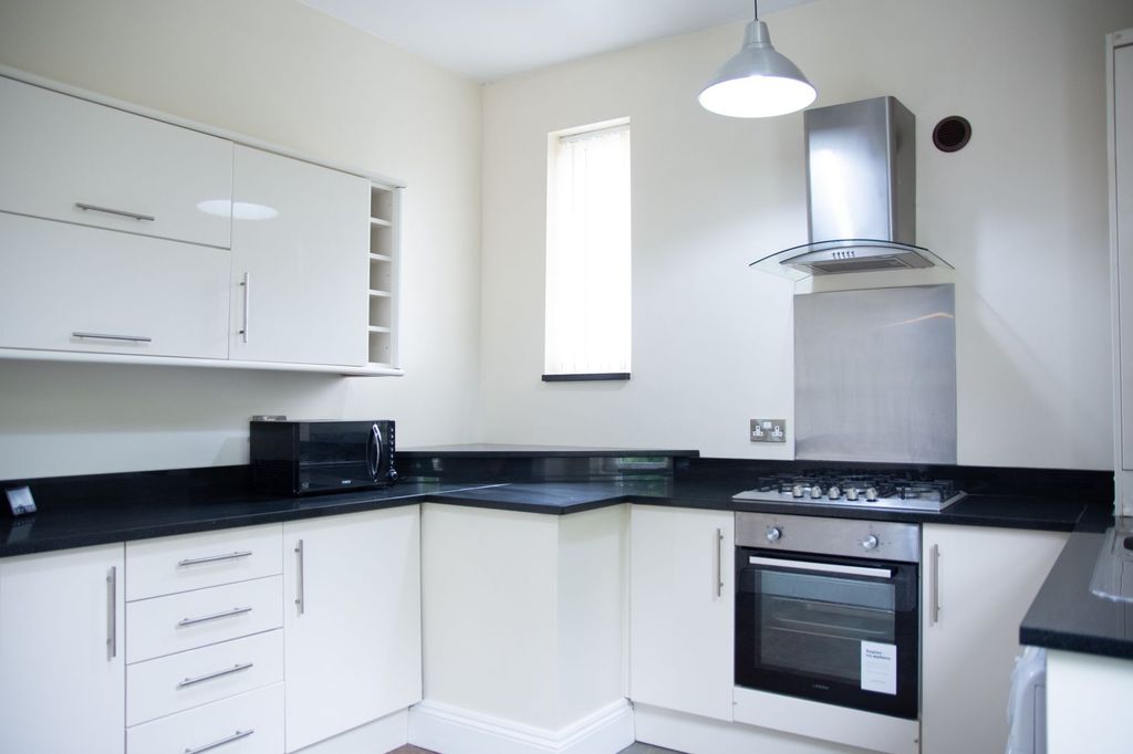 Property photo 1 of 5 Modern Kitchen With Sleek White Cabinets, Black Co...