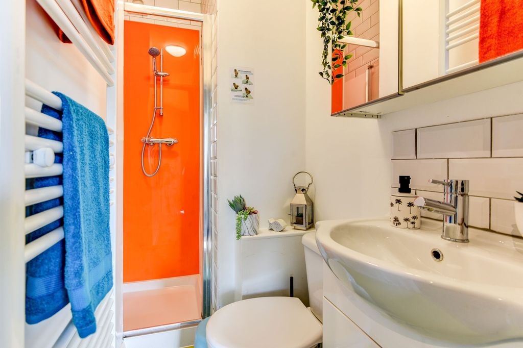 Property photo 2 of 5 A Modern Bathroom Featuring A Vibrant Orange Showe...