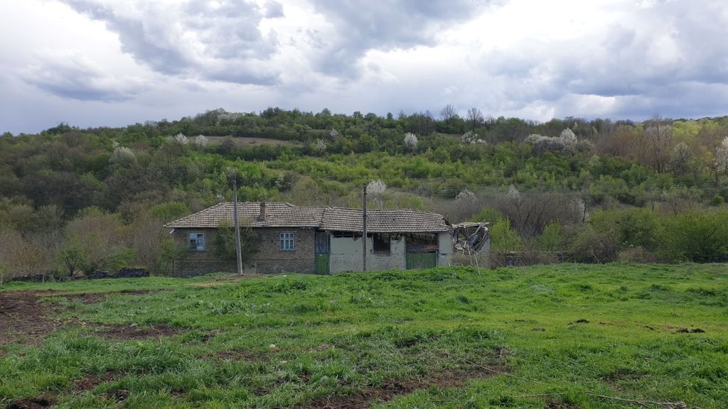 Property photo 1 of 41 View Of A Traditional Rural House With A Tiled Roof Set Against A Backdrop Of Green Hills And Trees Under A Cloudy Sky.