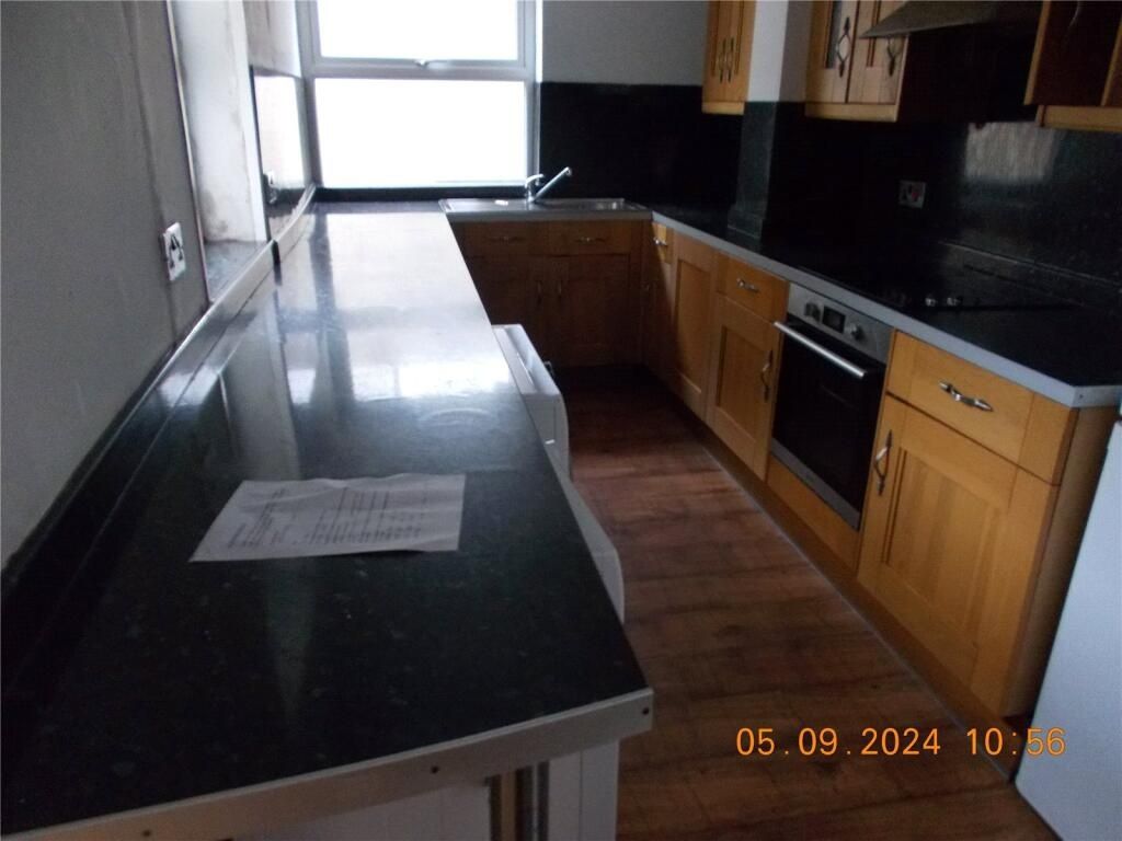 Property photo 3 of 8 Modern Kitchen Featuring Sleek Black Countertops, ...