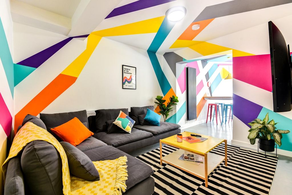 Property photo 2 of 5 This Vibrant Living Room Features Colorful Walls A...