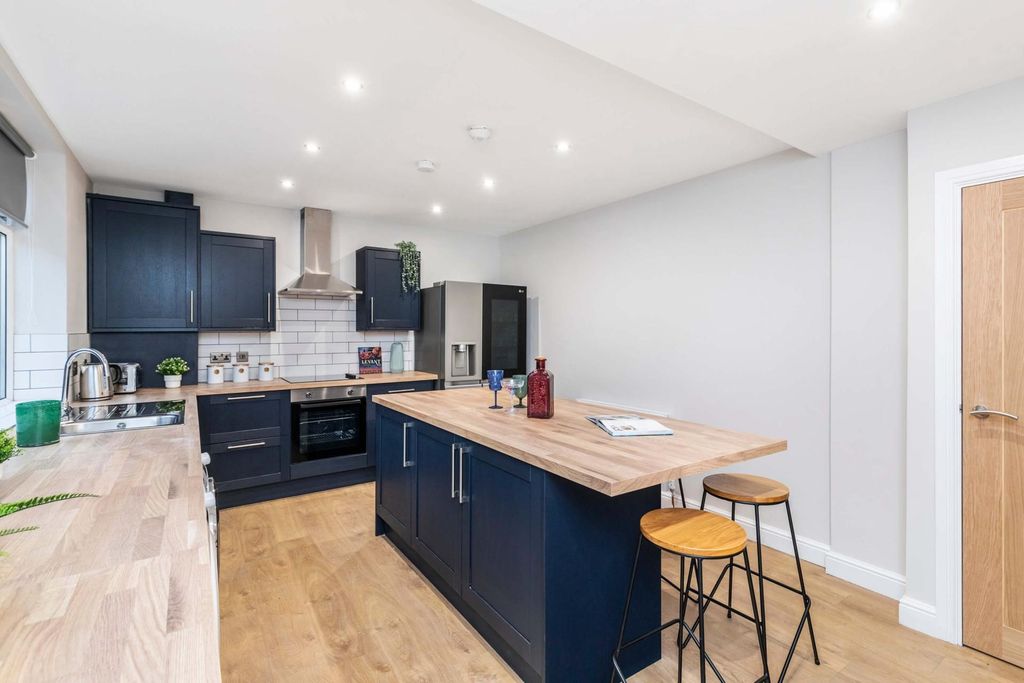 Property photo 3 of 15 Modern And Well-Lit Kitchen With Sleek Dark Cabine...