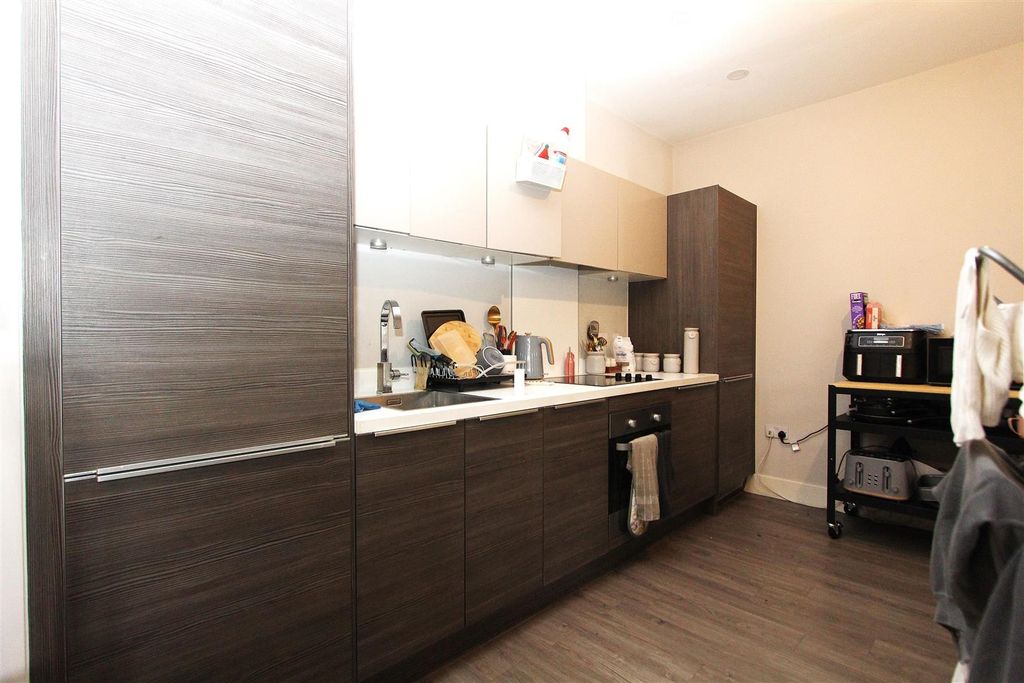 Property photo 2 of 6 Modern Kitchen With Sleek Dark Wood Cabinetry...