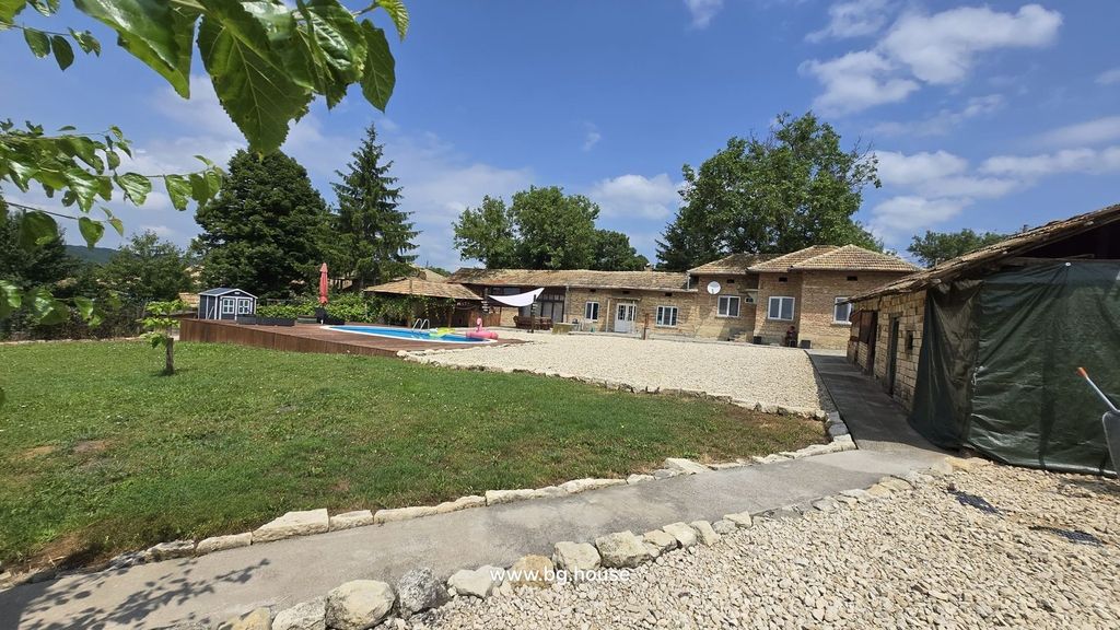 Property photo 1 of 100 Outdoor View Showing The Bulgarian House, Swimming Pool, Garden, And Surrounding Trees Under A Partly Cloudy Sky.