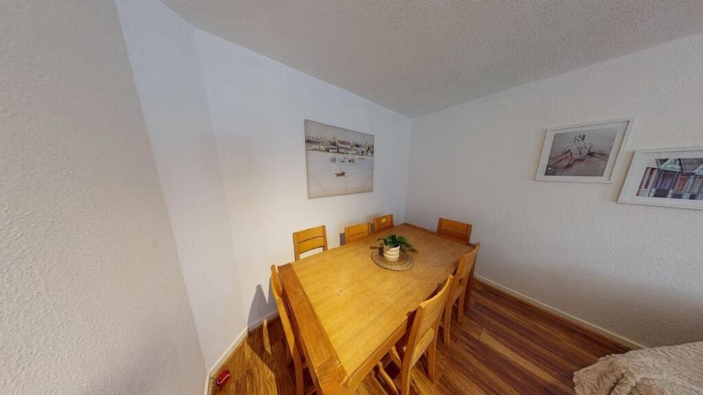 Property photo 2 of 11 A Cozy Dining Room With A Wooden Table Covered By ...