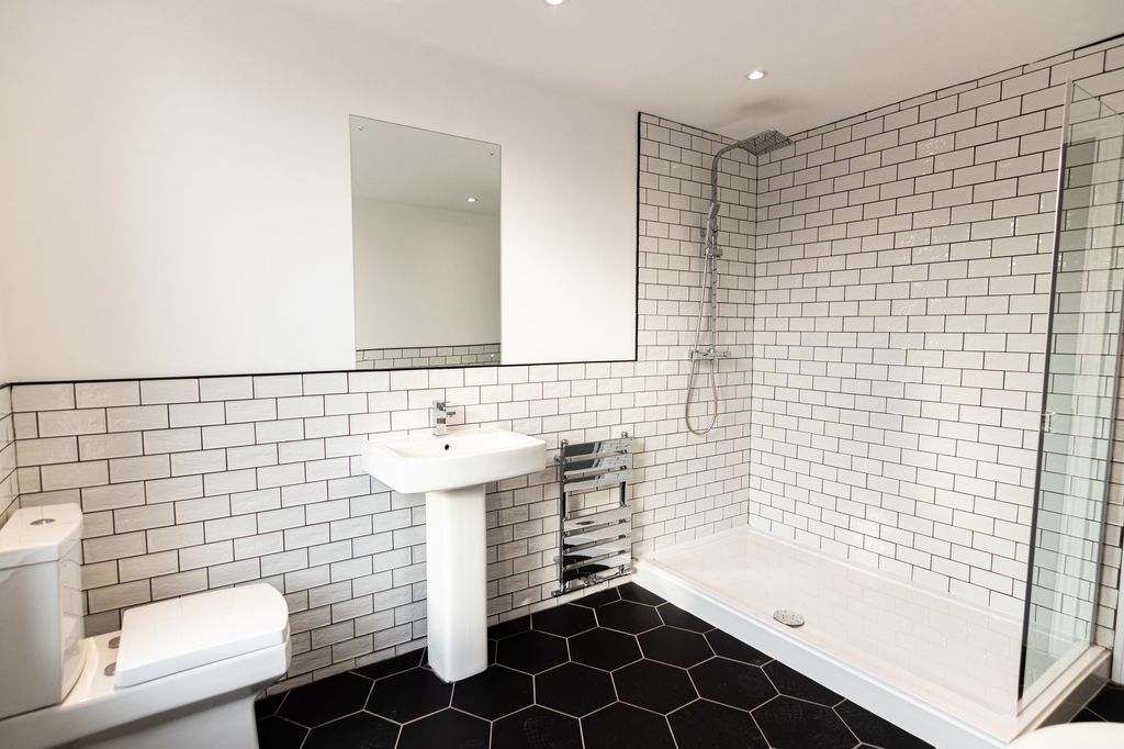 Property photo 2 of 15 Modern And Clean Bathroom Featuring White Subway T...