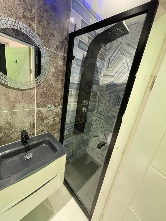 Property photo 2 of 12 Modern Bathroom With A Sleek Black Sink And A Cont...