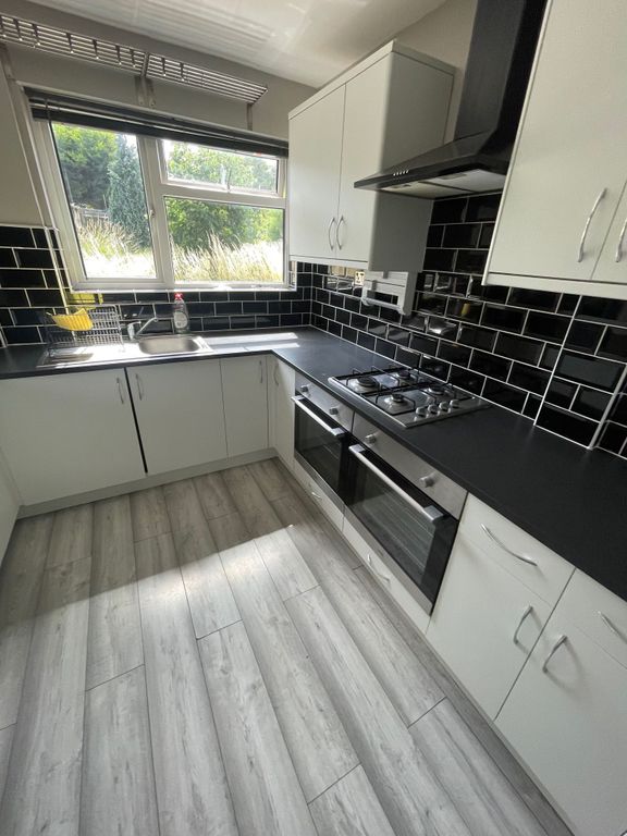 Property photo 3 of 14 Bright And Modern Kitchen Featuring Sleek Black Co...