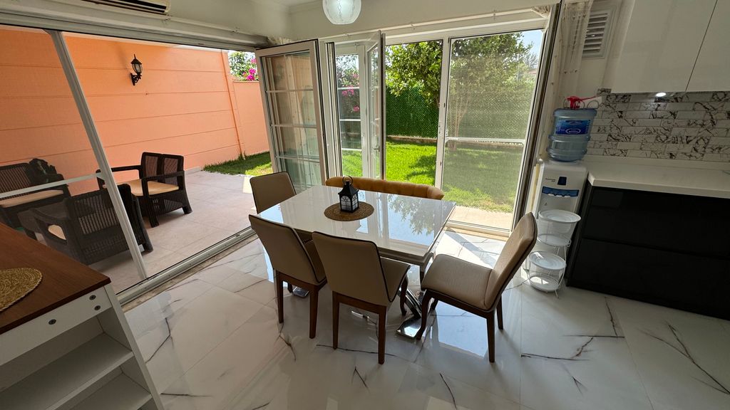 Property photo 3 of 12 An Immaculate Apartment In Belek, Antalya For Sale - Living Area Thats Leads Out To A Covered Terrace And Garden