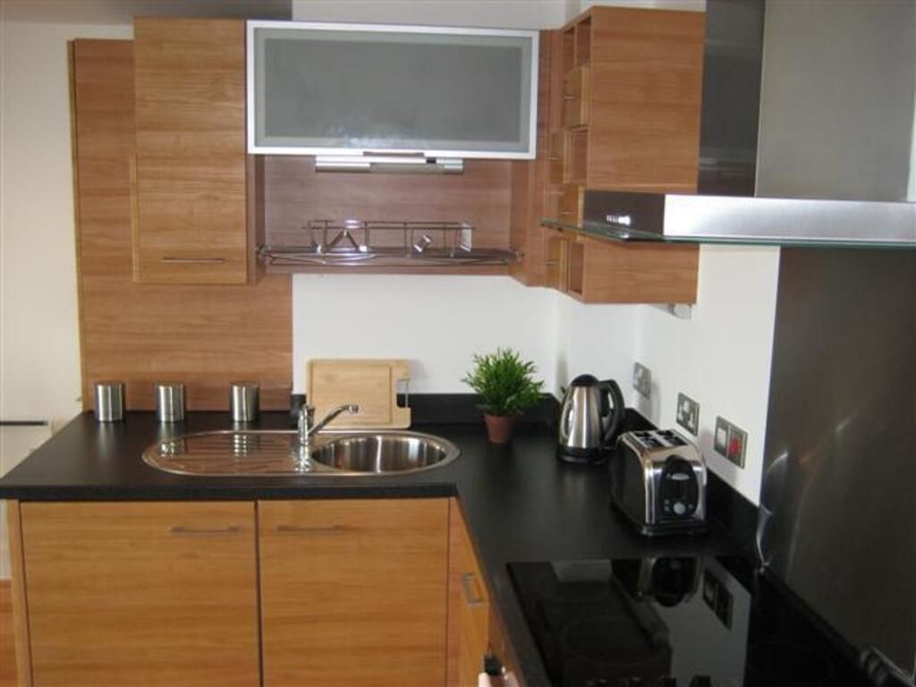 Property photo 1 of 7 A Modern Kitchen Featuring Sleek Wooden Cabinetry,...