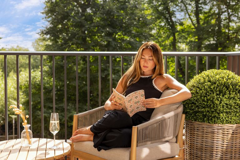 Property 3 of 7. Woman Reading A Book Whilst Sat On Her Balcony