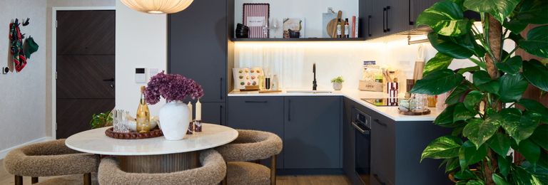Property 2 of 4. Kitchen, Navy Blue Cupboard Panels And White Countertops, Modern Appliances, Dining Table In