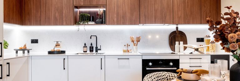 Property 2 of 4. Closeup Photo Of Decorated Dining Table, Kitchenette With Wooden-Finish Cupboards, White Cabinets