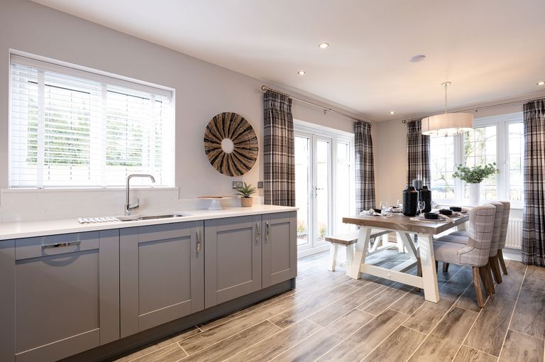 Property 3 of 10. A Modern And Cozy Kitchen With Gray Cabinets, A Wooden Dining Table